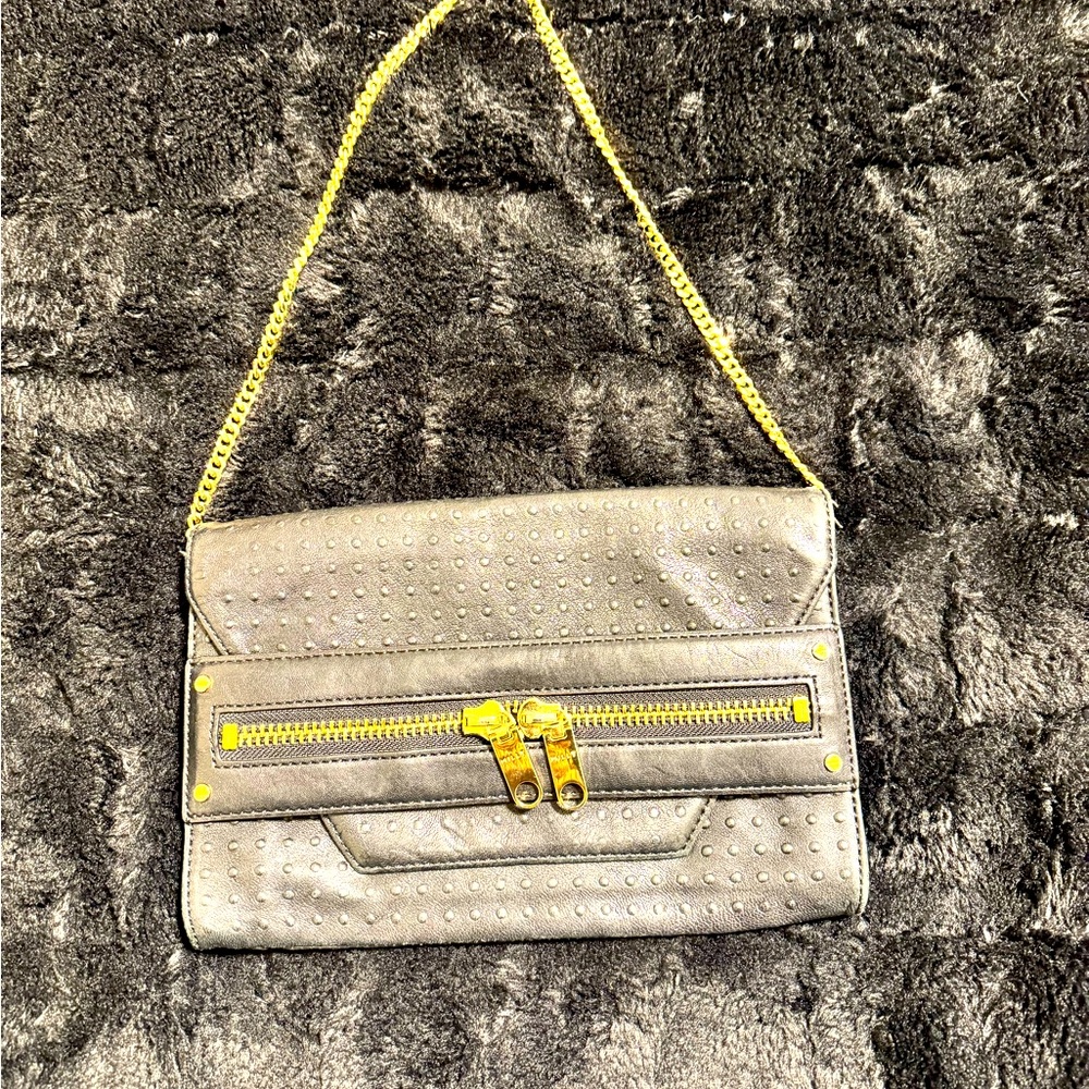 Black, genuine leather clutch with Pebbles leather on top gold hardware.